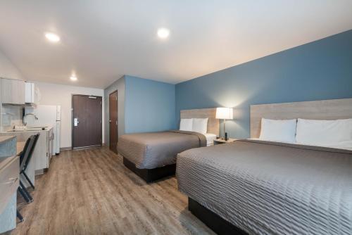 a hotel room with two beds and a kitchen at WoodSpring Suites Concord-Charlotte Speedway in Concord