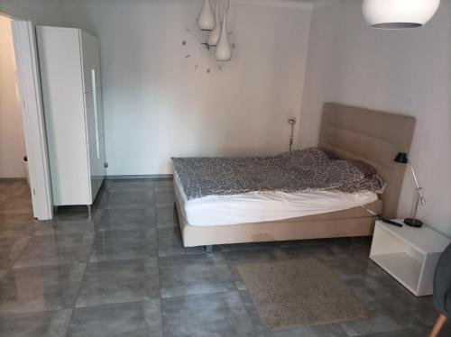 a bedroom with a bed and a tiled floor at Przy Katedrze in Koszalin