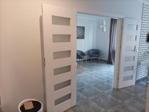 a sliding door leading into a room with a dining room at Przy Katedrze in Koszalin