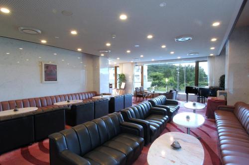 a restaurant with leather chairs and tables and a bar at Resorpia Kumihama in Kyotango