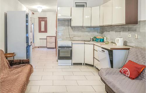 a small kitchen with white cabinets and a couch at Awesome Apartment In Dominikowo in Dominikowo