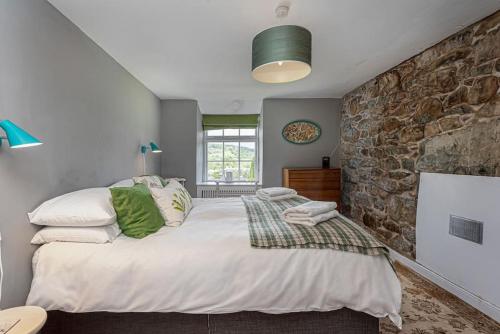 a bedroom with a large bed and a stone wall at Dolgellau Townhouse 2 Minutes to Town & Mountains in Dolgellau