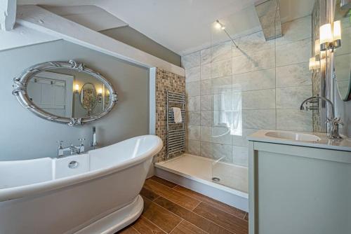 a bathroom with a white tub and a sink and a bath tub at Dolgellau Townhouse 2 Minutes to Town & Mountains in Dolgellau