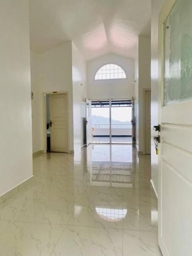 an empty room with a hallway with a large window at M town Homestay in Kodaikānāl