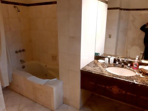 La salle de bains est pourvue d'un lavabo et d'une baignoire. dans l'établissement Hotel MAURY, à Lima