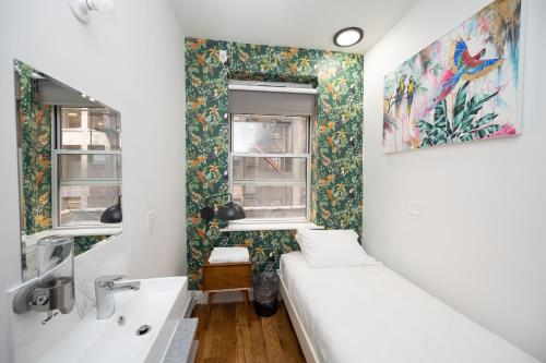a bathroom with a bed and a sink and a window at The Flat NYC in New York