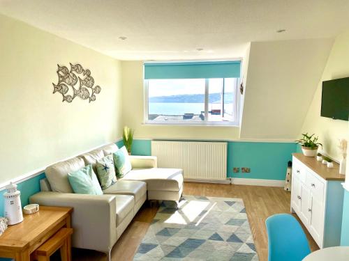 a living room with a couch and a window at Lighthouse View, one min from harbour & beach in Scarborough