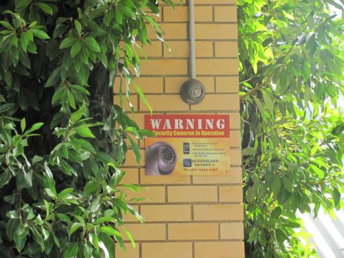 a warning sign on the side of a brick wall at Nambour Central Motel in Nambour