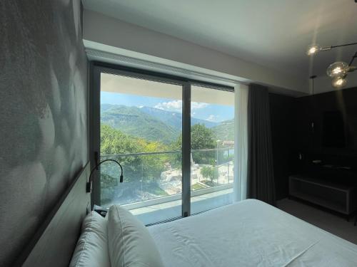 a bedroom with a large window with a mountain view at Hotel Ristorante Tre Lanterne & SPA in Acquasanta Terme