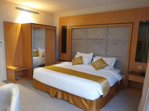a hotel room with a large white bed with gold pillows at Al Rayyan Tower in Jeddah