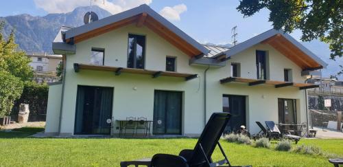 a house with chairs in front of it at I LAGHEE casette BREVA e TIVANO -garden-parking-Lake view - Bike friendly holiday house in Colico