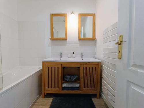 a bathroom with a sink and a bath tub at Gîte 4 personnes avec piscine et bain nordique proche des plages du débarquement in Le Manoir