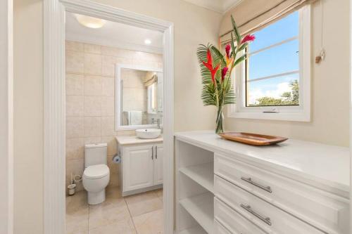 a bathroom with a toilet and a sink and a window at White Sands Beach Villas - Villas N- Lovely 1 Bed Condo in Christ Church