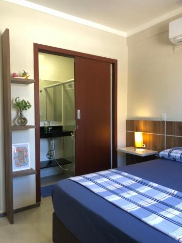 a bedroom with a blue bed and a mirror at Pousada Crisana in Florianópolis