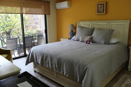 a bedroom with a large bed with a balcony at Hotel Boutique La Rioja in Atlixco