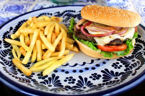 a hamburger and french fries on a blue and white plate at Hotel Boutique La Rioja in Atlixco