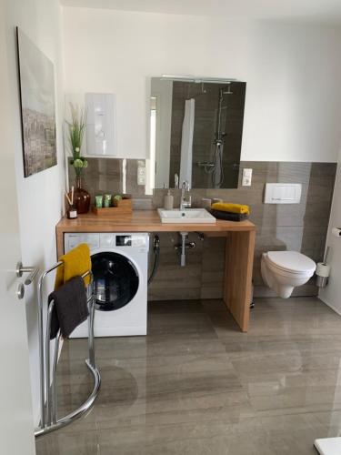 a bathroom with a washing machine and a sink at eifel24, neu, modern mit Dachterrasse in Schwirzheim