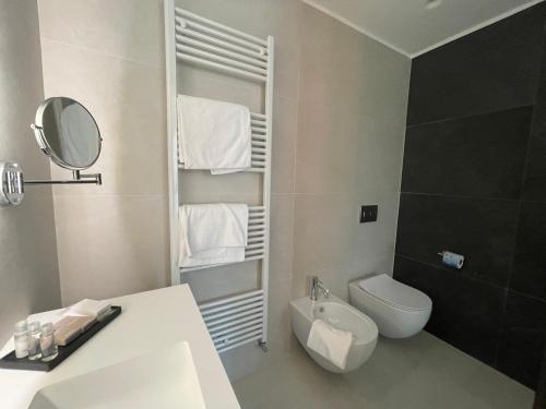 La salle de bains est pourvue de toilettes, d'un lavabo et d'un miroir. dans l'établissement Hotel Ristorante Tre Lanterne & SPA, à Acquasanta Terme