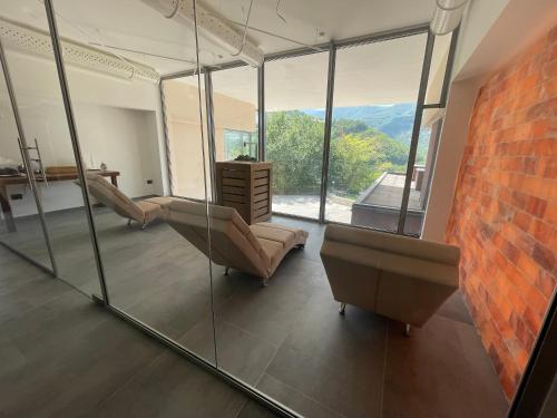 a living room with a couch and a glass wall at Hotel Ristorante Tre Lanterne & SPA in Acquasanta Terme