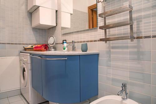 a bathroom with a blue sink and a washing machine at A due passi dal lago in Laveno-Mombello