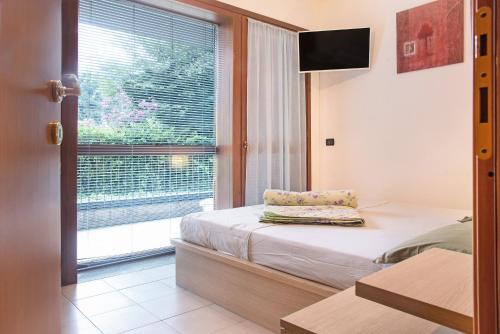 a small bedroom with a bed and a window at A due passi dal lago in Laveno-Mombello