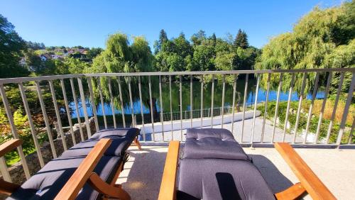 a balcony with chairs and a view of the water at Casa Barca Velha in Ponte da Barca