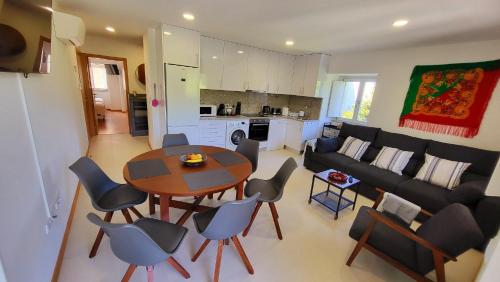 een woonkamer met een tafel en stoelen en een bank bij Casa Barca Velha in Ponte da Barca