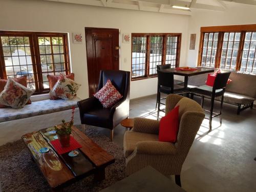 a living room with a couch and chairs and a table at Karibu Self-catering Accommodation in Hermanus