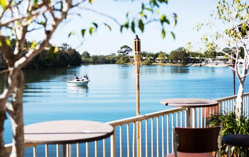 a boat on a river with people in it at Nightcap at Northern Grounds in Maroochydore
