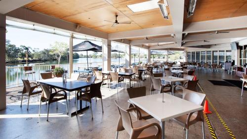 a restaurant with tables and chairs and a view of the water at Nightcap at Northern Grounds in Maroochydore