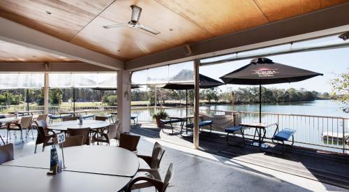 a restaurant with tables and chairs and a view of the water at Nightcap at Northern Grounds in Maroochydore