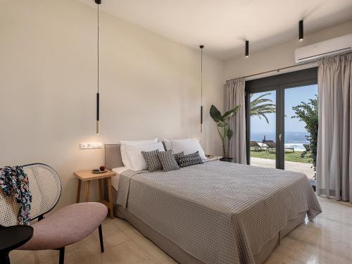 a bedroom with a bed and a view of the ocean at Villa Heora - The Floating Residence in Tria Monastiria