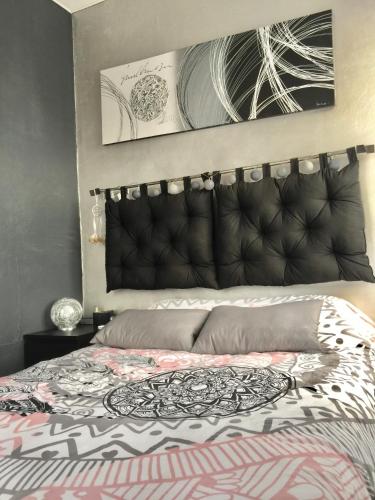 une chambre avec un lit avec une couette noire et blanche dans l'établissement appartement cocooning,proche centre et gare, à Caen