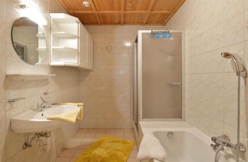baño blanco con ducha y lavamanos en Stegerbauer, en Kirchbichl