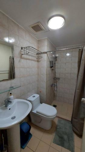 a bathroom with a toilet and a sink and a shower at N place at Soho Central in Manila
