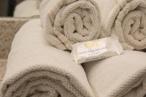 rolka białych ręczników z paczką koców ofitacyjnych w obiekcie Mariano Palace Hotel w mieście Campinas