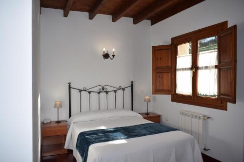a bedroom with a bed and a window at Apartamentos Rurales la Taberna in Matienzo