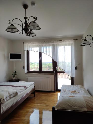 1 dormitorio con 2 camas y ventana grande en Pensjonat Na Wzgórzu, en Udryń