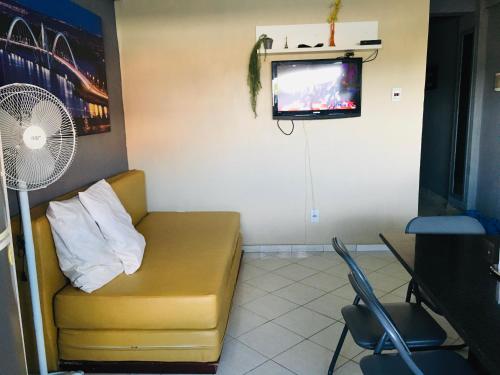 a room with a couch and a tv and a fan at Apartamento para temporada perto do aeroporto de Brasilia in Brasilia