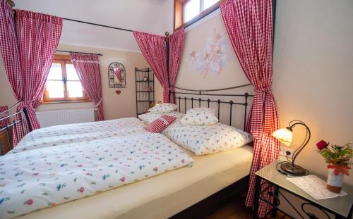 1 dormitorio con 1 cama con cortinas rosas en Troadkasten - Ferienhaus am BIO-Bergbauernhof en Aflenz Kurort