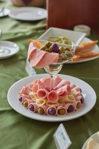 a plate of ham and olives and a wine glass on a table at Casona Plaza Hotel Colonial in Arequipa