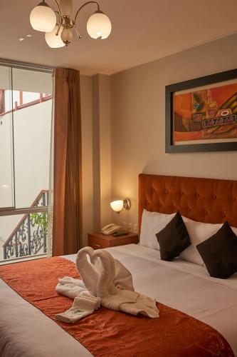 a hotel room with a bed with a towel on it at Casona Plaza Hotel Colonial in Arequipa