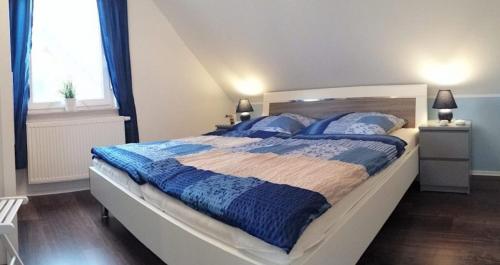um quarto com uma cama grande com cobertores e almofadas azuis em Ferienhaus Strandräuber em Marienfelde