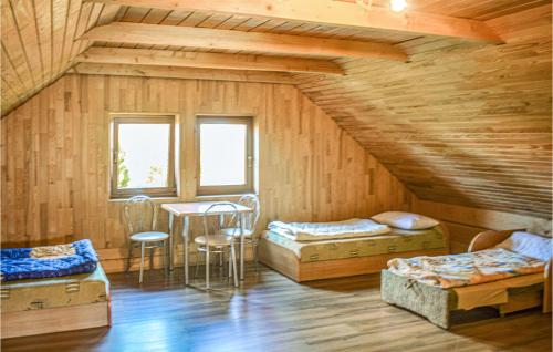 Cette chambre mansardée comprend deux lits et une table. dans l'établissement Gorgeous Home In Mscice With Kitchen, à Mścice