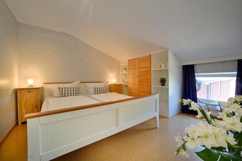 sypialnia z łóżkiem, oknem i kwiatami w obiekcie "Ferienhof Seelust" Ferienwohnung Lerche w mieście Gammendorf