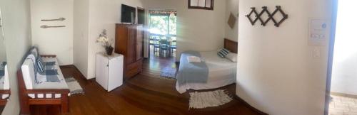 a living room with a bed and a wooden floor at Pousada Luar do Prata in Trindade