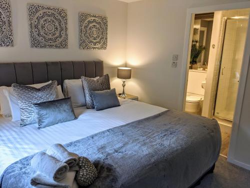 a bedroom with a large bed with blue pillows at Gleneagles Country Apartments in Auchterarder