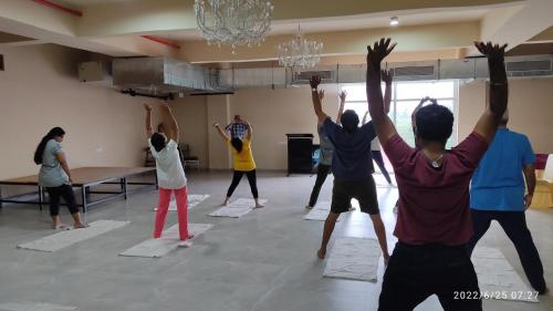a group of people doing yoga in a room at juSTa Rudra Resort & Spa in Kolād