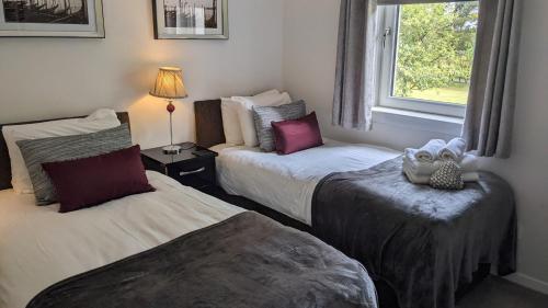 a hotel room with two beds and a window at Gleneagles Country Apartments in Auchterarder
