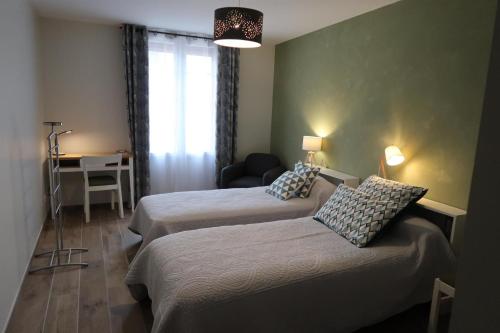 a hotel room with two beds and a desk at Les Prés de Bondus in Chéu